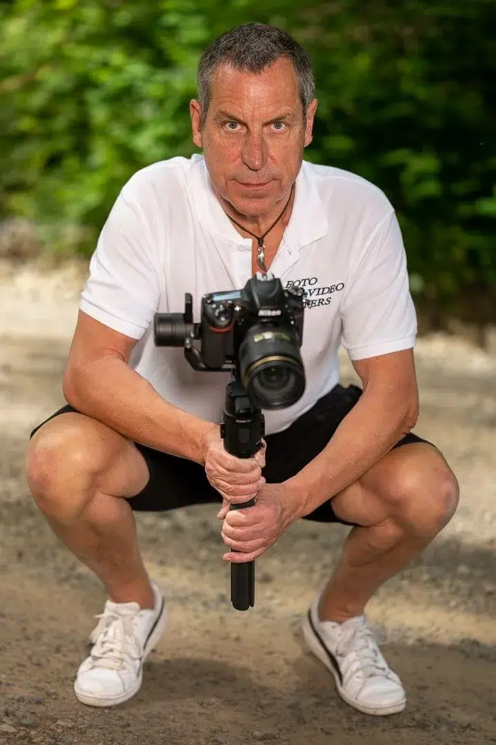 fotograf ralf peters aus boppard kniet mit gimbal und kamera und hält den daumen hoch.