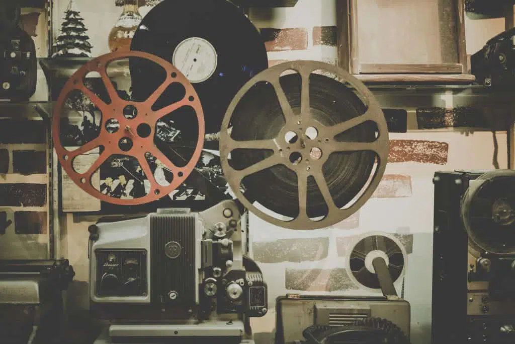 Alter Filmprojektor mit zwei Spulen, Retro-Fotozubehör im Hintergrund