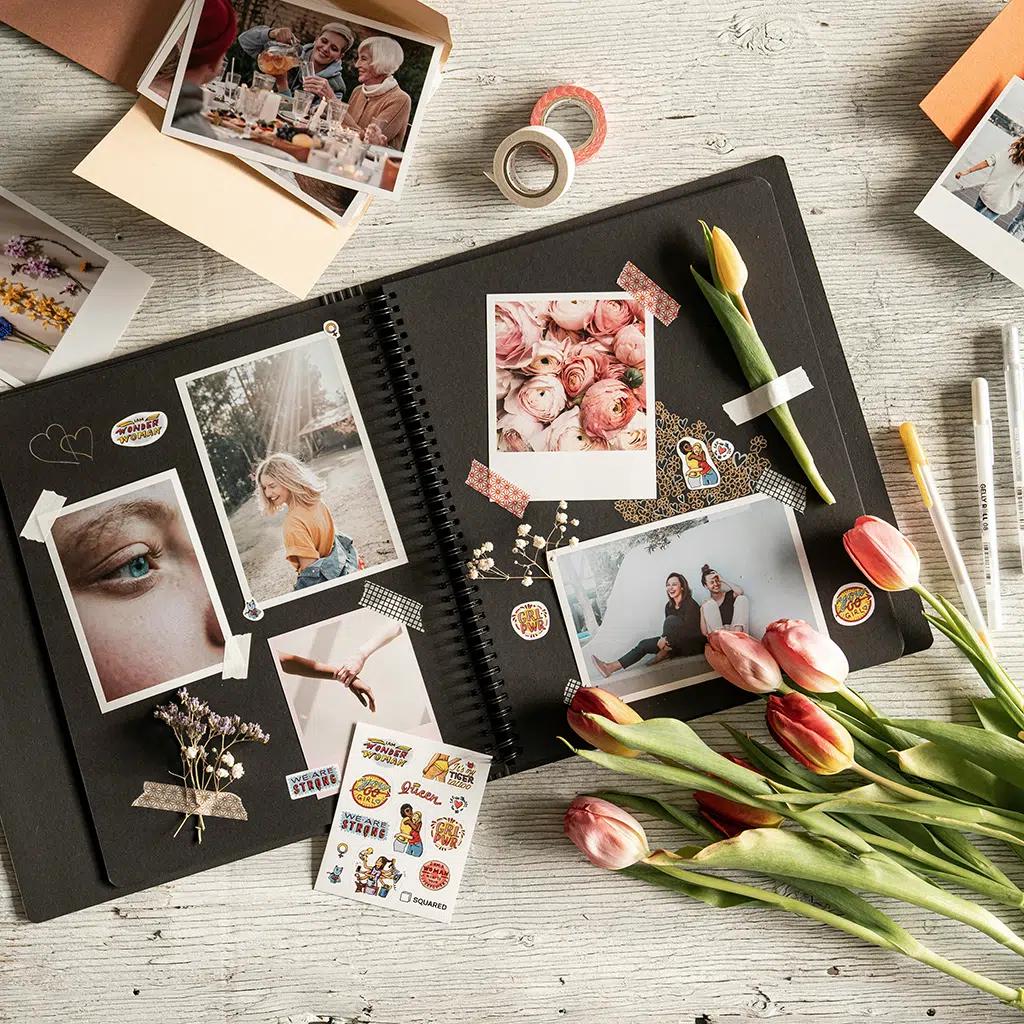 Geöffnetes Fotoalbum mit verschiedenen Beispielbildern, verziert mit Stickern und Washitape. Foto-Video-Peters in Boppard bietet hochwertige Fotoalbum-Gestaltung und Fotoprodukte.