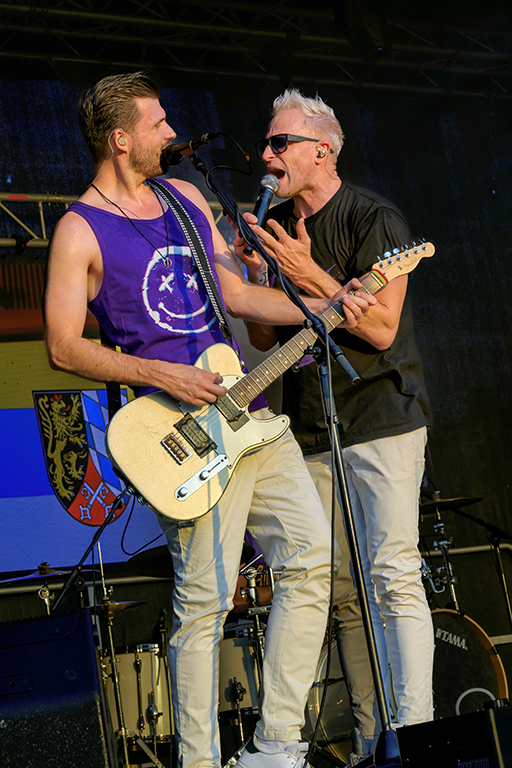 Sänger und Gitarrist von XTREME Musicshow gemeinsam am Mikrofon