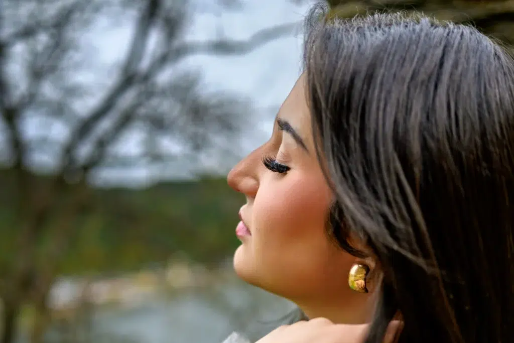 Junge Frau im Seitenprofil mit geschlossenen Augen vor Naturkulisse an der Burg Rheinfels am Rhein