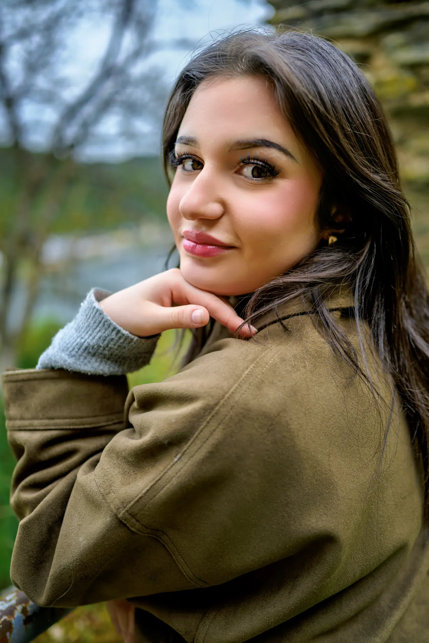 Junge Frau lehnt den Kopf an die Hand bei einem Outdoor Portrait Shooting