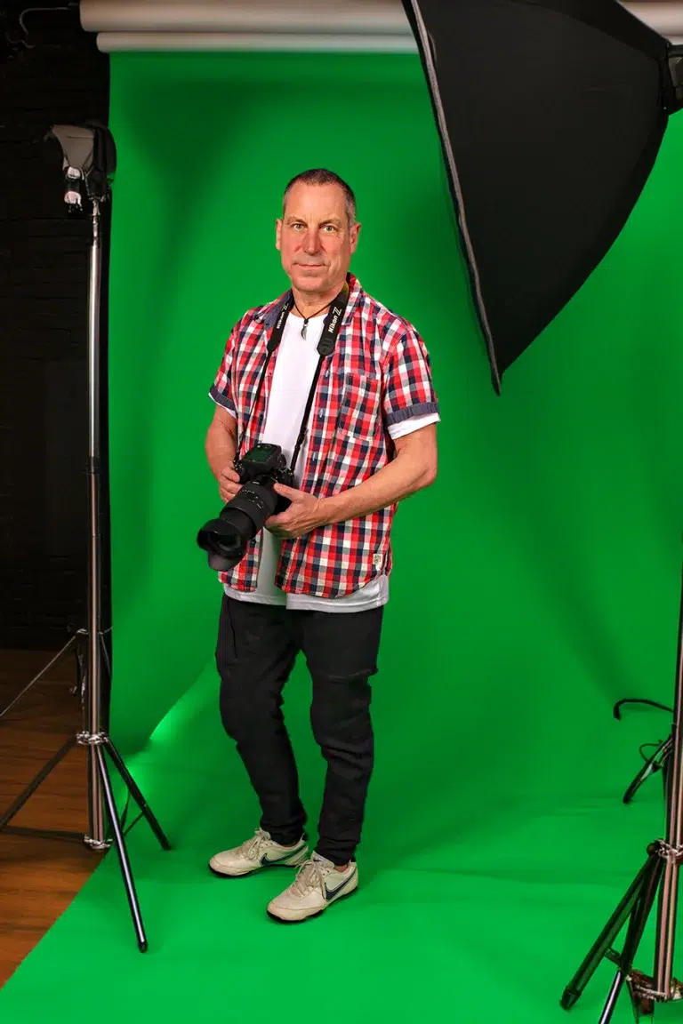 Fotograf im Fotostudio mit grünemHintergrund