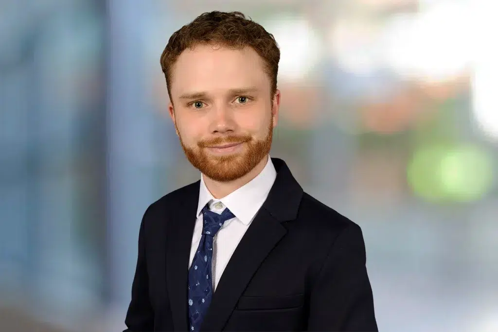 Businessporträt eines jungen Mannes im Anzug mit Krawatte vor hellem, stilvollem Hintergrund