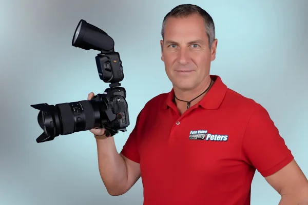 Fotograf Ralf Peters mit Kamera im Studio, Porträtaufnahme.