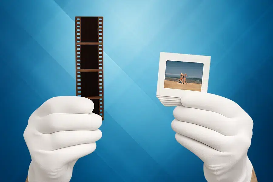 Hand hält einen Negativstreifen zum Digitalisieren von Fotos